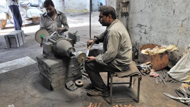 Workers busy making khukris at a workshop of the shop, Satish Khukri, in Dehradun on Wednesday.(Vinay Santosh Kumar / HT Photo)