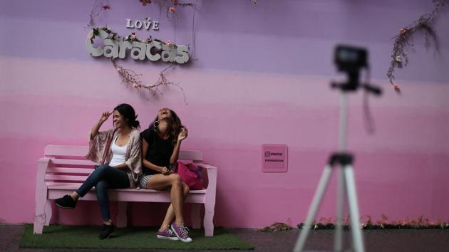 Ana Gabriela Alzola and Deniali Vega pose for a photograph at a backdrop used by customers to take pictures inside a mall in Caracas. For Venezuelans, queuing for food is a daily ordeal. They also are used to trying multiple pharmacies and hospitals in search of the medicines they need, and more recently have grown accustomed to collecting water from streams. (Ivan Alvarado / REUTERS) Ana Gabriela Alzola and Deniali Vega pose for a photograph at a backdrop used by customers to take pictures inside a mall in Caracas. For Venezuelans, queuing for food is a daily ordeal. They also are used to trying multiple pharmacies and hospitals in search of the medicines they need, and more recently have grown accustomed to collecting water from streams. (Ivan Alvarado / REUTERS)