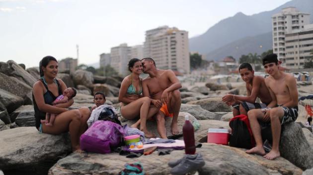 In search of distraction, Venezuelans in Caracas have long taken to the nearby seaside state of Vargas to spend weekends with family and friends on the shores of the Caribbean. “You put your mind in another place,” said Leonel Martinez (C), a soldier relaxing on the sand with his girlfriend while her nephews played nearby. “It’s a way to think about something besides what is happening in the country.” (Ivan Alvarado / REUTERS) In search of distraction, Venezuelans in Caracas have long taken to the nearby seaside state of Vargas to spend weekends with family and friends on the shores of the Caribbean. “You put your mind in another place,” said Leonel Martinez (C), a soldier relaxing on the sand with his girlfriend while her nephews played nearby. “It’s a way to think about something besides what is happening in the country.” (Ivan Alvarado / REUTERS)