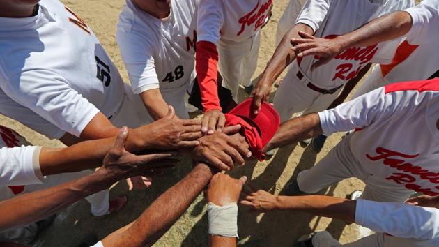 Members of Family Rose softball team put their hands together before a match at Lecuna Avenue softball pitch in Caracas. "After the game we always had a few beers. But now they are too expensive," said Felix Babaza. The wire fence that once surrounded the field was long ago stolen. The lights, which once allowed the group to play at night, were also pilfered. (Ivan Alvarado / REUTERS) Members of Family Rose softball team put their hands together before a match at Lecuna Avenue softball pitch in Caracas. "After the game we always had a few beers. But now they are too expensive," said Felix Babaza. The wire fence that once surrounded the field was long ago stolen. The lights, which once allowed the group to play at night, were also pilfered. (Ivan Alvarado / REUTERS)