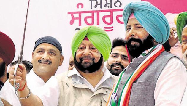 CM Amarinder Singh holding a sword during a rally in support of Congress candidate from Sangrur Kewal Singh Dhillon (right) as PWD minister Vijay Inder Singla (left) looks on.(Bharat Bhushan / HT Photo)