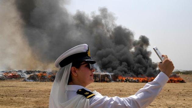 A member of the Pakistan Customs takes a picture beside a pile of burning illicit alcohol smuggled in the country and seized by the Pakistan Coast Guards, on the outskirts of Karachi, Pakistan. (Asif Hassan / AFP) A member of the Pakistan Customs takes a picture beside a pile of burning illicit alcohol smuggled in the country and seized by the Pakistan Coast Guards, on the outskirts of Karachi, Pakistan. (Asif Hassan / AFP)