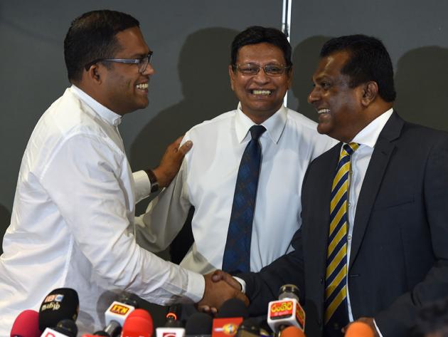 Sri Lanka's Sports Minister Harin Fernando (L) shakes hands with new President of Sri Lanka Cricket Shammi Silva (R) as new Sri Lanka Cricket (SLC) secretary Mohan De Silva looks (File Photo)(AFP)