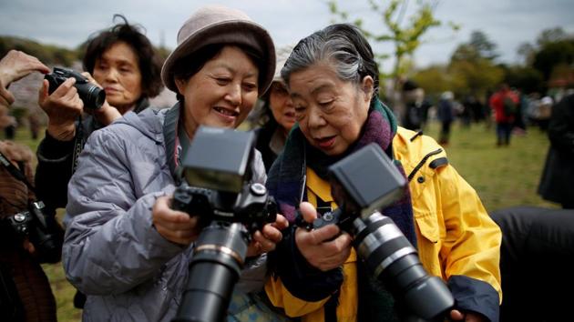 Fumiko Shirataki and her friend show each other photographs they took. But now she has honed her skills, and her house is filled with a huge number of photos. “Uncountable,” she said. “After all, it’s been 26 years.” (Issei Kato / REUTERS) Fumiko Shirataki and her friend show each other photographs they took. But now she has honed her skills, and her house is filled with a huge number of photos. “Uncountable,” she said. “After all, it’s been 26 years.” (Issei Kato / REUTERS)