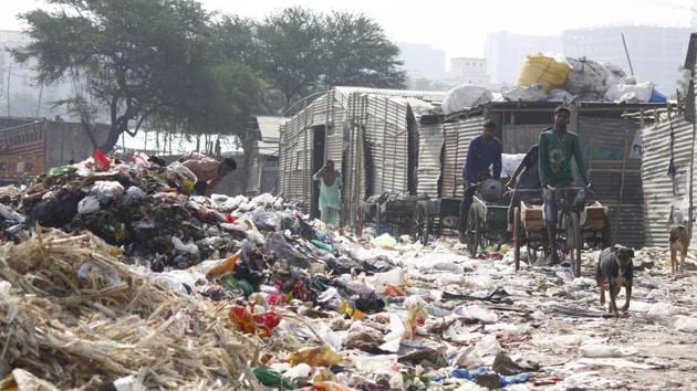 On a typical day in the slums of Nathupur, a village that borders Cyber City and DLF Phase 3, men can be seen sifting through the garbage that arrives in trucks.(Yogendra Kumar/HT PHOTO) On a typical day in the slums of Nathupur, a village that borders Cyber City and DLF Phase 3, men can be seen sifting through the garbage that arrives in trucks.(Yogendra Kumar/HT PHOTO)