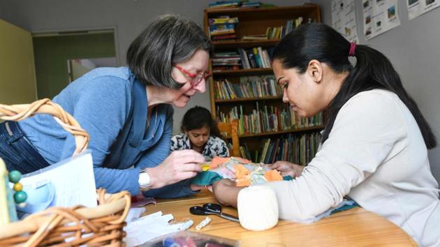 A volunteer (L) teaches a refugee how to sew. For the volunteers, though, the most frustrating aspect is the short duration of migrants’ stay as they built close ties with the exiles. Once their asylum demand is accepted, they have three months to leave the centre. Those who obtain the right to stay in France often move to Mulhouse, however, where the jobs pool is bigger. (Sebastien Bozon / AFP) 