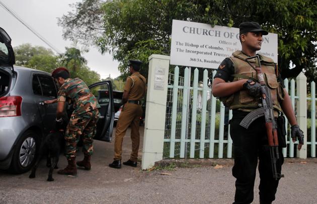 Security personnel stand guard outside an Anglican church before a service, a week after a string of suicide bomb attacks across the island on Easter Sunday.(REUTERS)