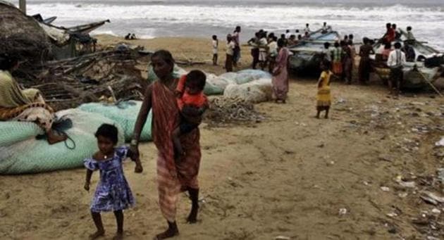 A woman evacuates the coast with her children in Ganjam district, Odisha following a cyclone alert.(AP PHOTO)