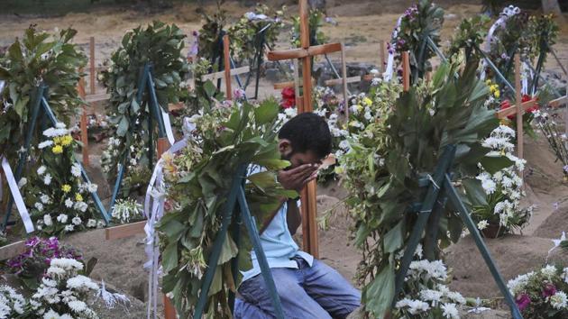 A Sri Lankan relative of a victim of Easter Sunday bomb blasts pays tribute at the burial site. Indian intelligence agencies are investigating if the Sri Lankan bombers had any link with radical elements in south India, and Kerala in particular. (AP) A Sri Lankan relative of a victim of Easter Sunday bomb blasts pays tribute at the burial site. Indian intelligence agencies are investigating if the Sri Lankan bombers had any link with radical elements in south India, and Kerala in particular. (AP)