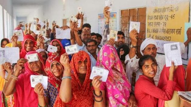 Election Results 2019: People show their voter's identity cards as they wait in queues to cast their votes at a polling station(PTI)