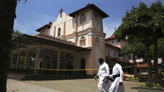 Catholic priests walk outside St. Sebastian’s Church. But from outside the church, if one moves past the police tape and stands far enough away ignoring its cordon, one might think nothing had happened there at all. (Manish Swarup / AP) Catholic priests walk outside St. Sebastian’s Church. But from outside the church, if one moves past the police tape and stands far enough away ignoring its cordon, one might think nothing had happened there at all. (Manish Swarup / AP)
