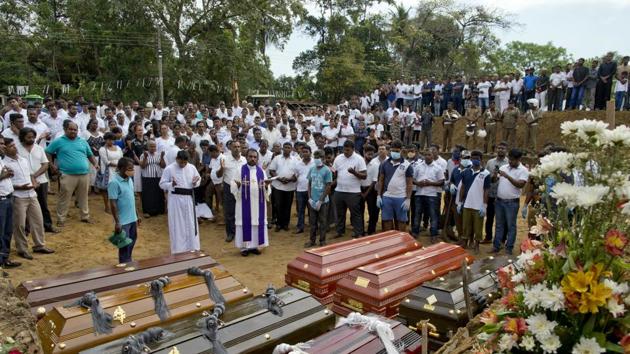 A priest conducts religious rituals during a mass burial for Easter Sunday bomb blast victims in Negombo. St. Sebastian’s walls are now blackened near where the bomber stood when he killed himself, spraying shrapnel in every direction. From inside, one can see destruction wherever the eye falls. (Gemunu Amarasinghe / AP) A priest conducts religious rituals during a mass burial for Easter Sunday bomb blast victims in Negombo. St. Sebastian’s walls are now blackened near where the bomber stood when he killed himself, spraying shrapnel in every direction. From inside, one can see destruction wherever the eye falls. (Gemunu Amarasinghe / AP)
