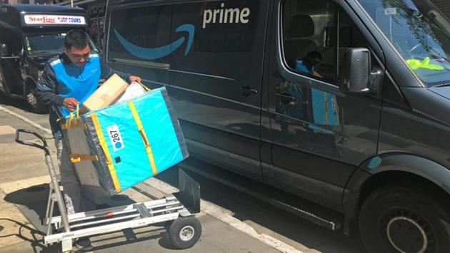 FILE PHOTO: An Amazon worker loads a trolley from a Prime delivery van in Los Angeles, California, U.S. February 25, 2019. REUTERS/Chris Helgren/File Photo(REUTERS)