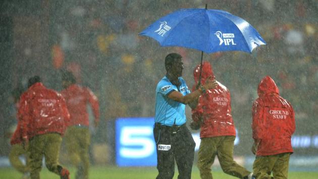 An umpire (C) and ground staff run for cover as rain delays the start of the 2019 Indian Premier League (IPL. (AFP)