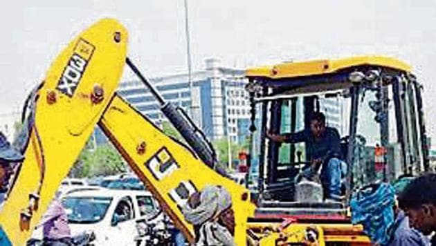An earthmover removes soil above the damaged pipeline, which threw traffic into disarray. (HT Photo) An earthmover removes soil above the damaged pipeline, which threw traffic into disarray. (HT Photo)