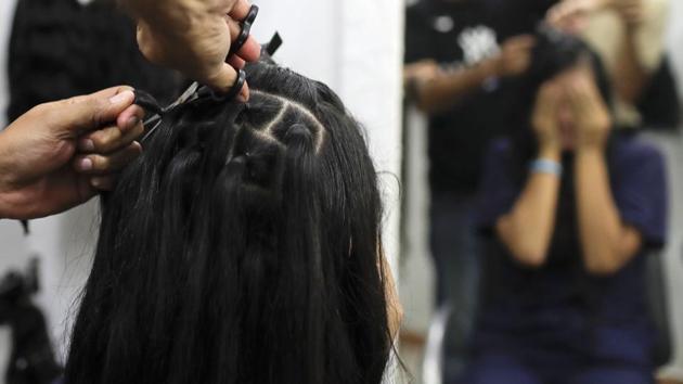 Valery Diaz covers her face as she gets her hair cut off. Díaz covered her eyes and held her breath before looking in a hair salon mirror to see herself without much of the long dark hair that used to frame her face. (Natacha Pisarenko / AP) Valery Diaz covers her face as she gets her hair cut off. Díaz covered her eyes and held her breath before looking in a hair salon mirror to see herself without much of the long dark hair that used to frame her face. (Natacha Pisarenko / AP)
