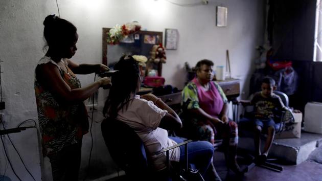 Hair dresser Rosevel Velazquez attends a customer at her beauty salon, which she runs out of her home in Caracas. Some salon workers have started bartering hair stylings, manicures and pedicures for food at a time when Venezuela’s sharp economic decline has led to shortages of food and medicine, and made salaries nearly worthless. (Natacha Pisarenko / AP) Hair dresser Rosevel Velazquez attends a customer at her beauty salon, which she runs out of her home in Caracas. Some salon workers have started bartering hair stylings, manicures and pedicures for food at a time when Venezuela’s sharp economic decline has led to shortages of food and medicine, and made salaries nearly worthless. (Natacha Pisarenko / AP)