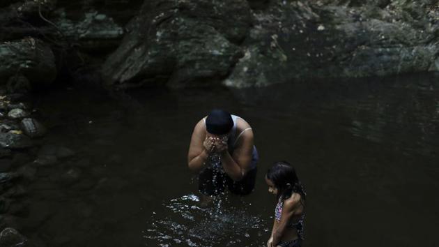 Liz Vargas and her niece Camila Vargas bathe on the skirt of a mountain in Avila National Park in Caracas. Vargas said she hasn’t had running water at home for the previous 15 days, alluding to frequent water shortages caused by nationwide blackouts that shut off water pumps. This was the first time she’d come to bathe where she used to swim for fun. (Natacha Pisarenko / AP) Liz Vargas and her niece Camila Vargas bathe on the skirt of a mountain in Avila National Park in Caracas. Vargas said she hasn’t had running water at home for the previous 15 days, alluding to frequent water shortages caused by nationwide blackouts that shut off water pumps. This was the first time she’d come to bathe where she used to swim for fun. (Natacha Pisarenko / AP)