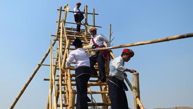 The rocket is laid in position, the trajectory carefully adjusted. The team captain takes a drag from a cigarette then uses it to light the fuse, before clambering down the bamboo rungs as the rocket lifts off with a deafening roar. (Ye Aung Thu / AFP)