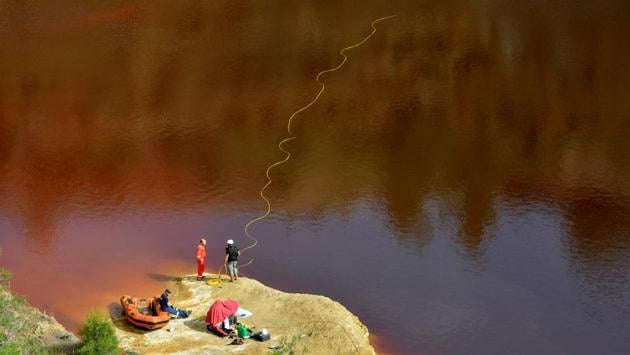 Forensics officers search Kokkinopezoula lake, also known as ‘red lake’, for possible bodies of victims of a suspected serial killer near the village of Mitsero, Cyprus. (Stefanos Kouratzis / REUTERS)