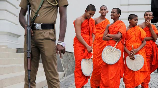 Monks are seen next to a security personnel after a Buddhist ceremony as a tribute to victims, a week after a string of suicide bomb attacks across the island on Easter Sunday, outside Kingsbury Hotel in Colombo, Sri Lanka. (Thomas Peter / REUTERS)