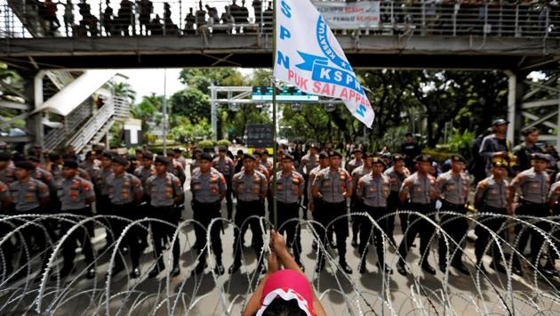 A worker holds a flag during a May Day protest near the National Monument (Monas) in Jakarta, Indonesia. (Willy Kirniawan / REUTERS)