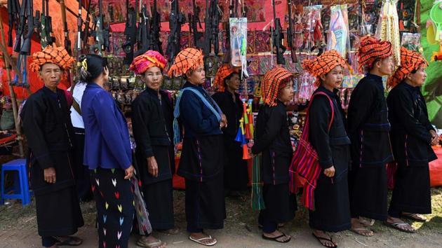 Pa'O ethnic women visit a stall during the festival. People dress in their finest, donning dark tunics and trousers in mourning for the kingdom they lost to the Bamar (Burmese) nearly 1,000 years ago. But their headwear make up for their sombre attire. Many women opt for a traditional bright orange cloth, symbolising the dragon. (Ye Aung Thu / AFP)