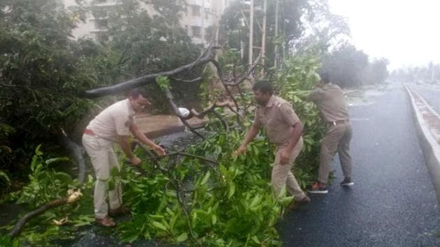 Police personnel of Nayapalli police station clear roads in Bhubaneswar on Friday. Several trees have been uprooted in the heavy rain and strong winds due to cyclone Fani which hit the region.(ANI)