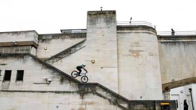 A cyclist steers down the narrow handrail of a stairway on Waterloo Bridge in London, England. (Henry Nichols / REUTERS)