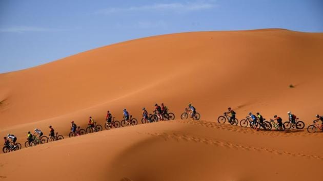 Competitors ride their bikes along sand dunes during Stage 1 of the 14th edition of Titan Desert 2019 mountain biking race around Merzouga in Morocco. (Franck Fife / AFP)