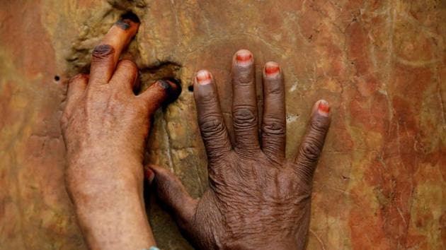 A worshipper places her fingers inside holes in a column that form the shape of a cross before the arrival of the Holy Fire, at the Church of the Nativity in Bethlehem, in the Israeli-occupied West Bank. (Raneen Sawafta / REUTERS)
