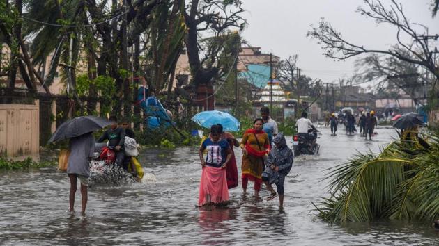 Puri: People wade through a flooded street after Cyclone Fani made its landfall, in Puri(PTI)