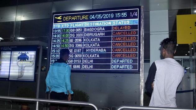 Flight passengers look at a display board at Lokpriya Gopinath Bordoloi International Airport as the airlines resume operation following a halt in view of the cyclonic storm Fani, in Guwahati, Saturday, May 4, 2019.(PTI photo)