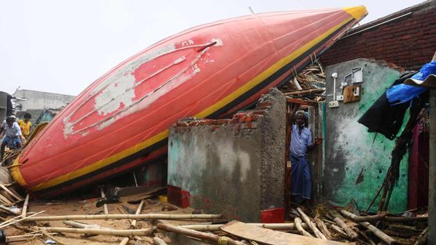 A man looks out from a damaged building, with a fishing boat lodged on the roof, along the seafront in Puri after Cyclone Fani swept through the area. The cyclone also triggered heavy rainfall in the state. It left three people dead and over 160 injured along with leaving behind a trail of destructions that included damaged houses, uprooted trees and electricity poles. (Dibyangshu Sarkar / AFP) A man looks out from a damaged building, with a fishing boat lodged on the roof, along the seafront in Puri after Cyclone Fani swept through the area. The cyclone also triggered heavy rainfall in the state. It left three people dead and over 160 injured along with leaving behind a trail of destructions that included damaged houses, uprooted trees and electricity poles. (Dibyangshu Sarkar / AFP)