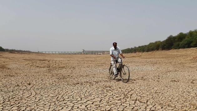 An Indian cyclist rides along dry bed of Sabarmati river near the Sant Sarovar, a reservoir situated in Gujarat's capital Gandhinagar. Gujarat is currently facing acute water crisis and government is making all efforts to reduce the scarcity of drinking water for people. But for farming, cattle remains a challenging task. (Sam Panthaky / AFP) An Indian cyclist rides along dry bed of Sabarmati river near the Sant Sarovar, a reservoir situated in Gujarat's capital Gandhinagar. Gujarat is currently facing acute water crisis and government is making all efforts to reduce the scarcity of drinking water for people. But for farming, cattle remains a challenging task. (Sam Panthaky / AFP)