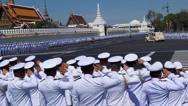 Officials salute as the car carrying King Maha Vajiralongkorn and Queen Suthida drives past the Grand Palace during his coronation in Bangkok. The queen, 40, was deputy commander of the king’s royal guard before her marriage to Vajiralongkorn, which was announced days before the coronation. (Jorge Silva / REUTERS) Officials salute as the car carrying King Maha Vajiralongkorn and Queen Suthida drives past the Grand Palace during his coronation in Bangkok. The queen, 40, was deputy commander of the king’s royal guard before her marriage to Vajiralongkorn, which was announced days before the coronation. (Jorge Silva / REUTERS)