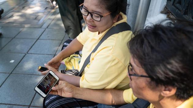 People watch a live broadcast of the coronation of Thai King Maha Vajiralongkorn on a smartphone in Bangkok. Vajiralongkorn displayed a different approach from his father since taking the throne more than two years ago. (Nicolas Axelrod / Bloomberg) People watch a live broadcast of the coronation of Thai King Maha Vajiralongkorn on a smartphone in Bangkok. Vajiralongkorn displayed a different approach from his father since taking the throne more than two years ago. (Nicolas Axelrod / Bloomberg)