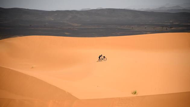 A competitor pushes a bicycle along a sand dune during Stage 2. Beginning in 2006 with four stages and 143 riders, the Titan Desert has grown to the 675 participants and six gruelling stages witnessed this year. (Franck Fife / AFP) A competitor pushes a bicycle along a sand dune during Stage 2. Beginning in 2006 with four stages and 143 riders, the Titan Desert has grown to the 675 participants and six gruelling stages witnessed this year. (Franck Fife / AFP)