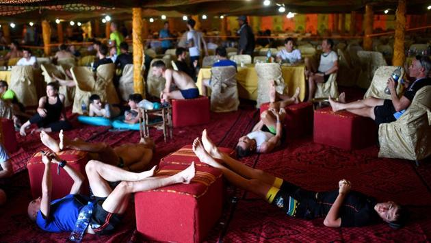 Competitors rest at the bivouac after taking part in the second stage, between Merzouga and Ouzina. The race logistics saw the relocation of a 24,000 m2 bivouac or temporary shelter accompany the participants across the dunes. (Franck Fife / AFP) Competitors rest at the bivouac after taking part in the second stage, between Merzouga and Ouzina. The race logistics saw the relocation of a 24,000 m2 bivouac or temporary shelter accompany the participants across the dunes. (Franck Fife / AFP)