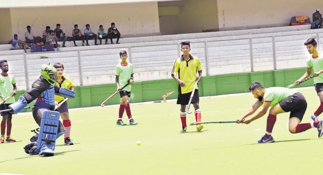 Raja Bangla Sports Club (green) in action against Kids XI at the Dr Babasaheb Ambedkar hockey tournament played at Major Dhyan Chand hockey poligras stadium.(HT PHOTO)