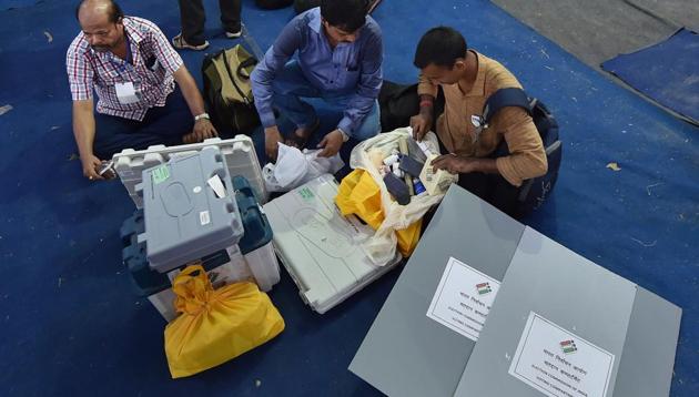 Poll officials check EVMs and VVPAT machines at a distribution centre.(PTI file photo)