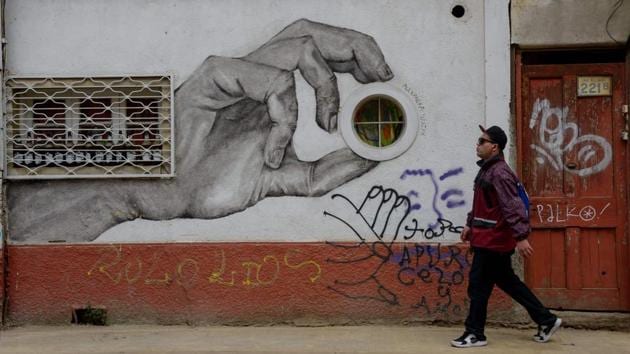 A man walks past a street mural in Valparaiso. There are almost 1,400 murals and graffiti artworks in the city and for the last five years they’ve found a place on the city’s tourism circuit, alongside views of the bay, colorful homes that hang from its steep hills, and its old funiculars and trams. (Martin Bernetti / AFP) A man walks past a street mural in Valparaiso. There are almost 1,400 murals and graffiti artworks in the city and for the last five years they’ve found a place on the city’s tourism circuit, alongside views of the bay, colorful homes that hang from its steep hills, and its old funiculars and trams. (Martin Bernetti / AFP)