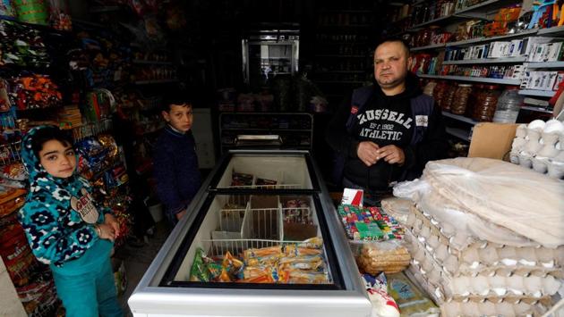 Behind one street of entirely collapsed buildings is a mechanic’s garage where workers are elbow deep in the engine of Karim’s taxi. Across the main street, the al-Burr family lives down another side street. Hussein (R), 41, minds the grocery shop, selling tins and packets of food, eggs and sweets. (Omar Sanadiki / REUTERS) Behind one street of entirely collapsed buildings is a mechanic’s garage where workers are elbow deep in the engine of Karim’s taxi. Across the main street, the al-Burr family lives down another side street. Hussein (R), 41, minds the grocery shop, selling tins and packets of food, eggs and sweets. (Omar Sanadiki / REUTERS)
