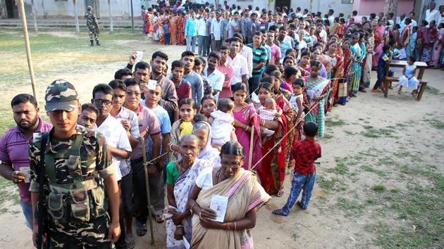 A Sashastra Seema Bal (SSB) trooper stands guard as people wait in queues to cast their votes outside a polling station during the third phase of general election in Khowai district in the northeastern state of Tripura, India, April 23, 2019.(REUTERS)