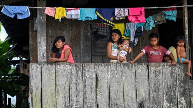 Colombian natives of the Wounaan ethnic group stand at their house on the banks of the San Juan river. For hundreds of miles along Colombia’s Pacific coast, with its thick, lush jungle, there are no hospitals, and medics and medicine are rare. And so, the San Raffaele hospital ship, when it arrives, is treated like a ghostly miracle by the poor indigenous and Afro-Caribbean communities that dot this violent region. (Raul Arboleda  / AFP) 