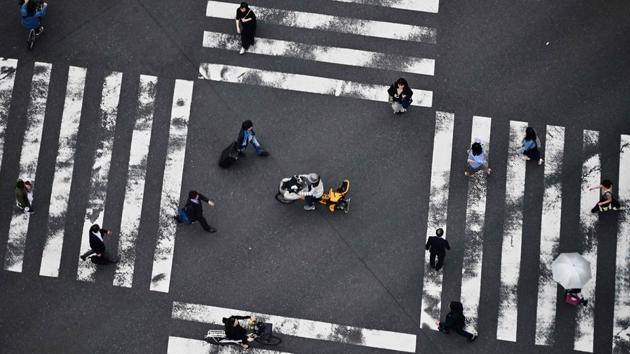 People cross a street in Tokyo’s Ginza district in Japan. (Charly Triballeau / AFP) People cross a street in Tokyo’s Ginza district in Japan. (Charly Triballeau / AFP)