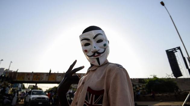 A Sudanese protester wears a Guy Fawkes mask outside the army headquarters in Khartoum, Sudan. (Mohamed el-Shahed / AFP) A Sudanese protester wears a Guy Fawkes mask outside the army headquarters in Khartoum, Sudan. (Mohamed el-Shahed / AFP)