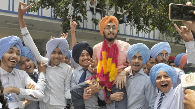 Saravjot got a hero’s welcome at Shalimar Model Senior Secondary School, Ludhiana, after his classmates carried him on their shoulders and danced to the beat of the dhol with teachers and the principal joining in.(Gurminder Singh/HT photo)