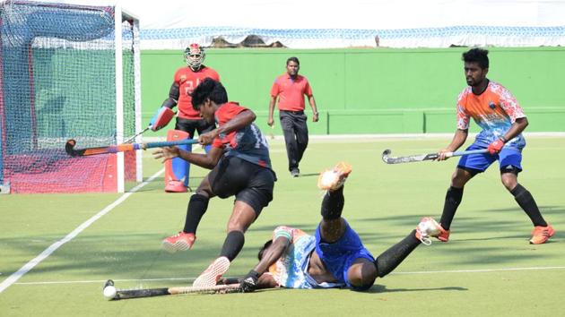 The players of Excellency Academy (orange and blue) and Food Corporation of India (FCI) in action during the Dr Babasaheb Ambedkar hockey tournament at the Major Dhyan Chand hockey poligras stadium, Nehrunagar , Pimpri on Friday.(HT PHOTO)