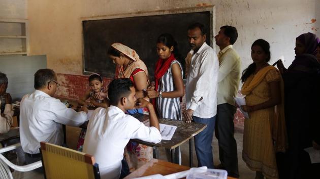 People queue up to cast their vote at a polling booth in Uttar Pradesh.(AP)